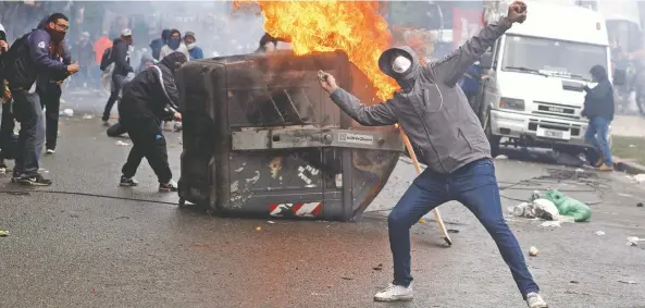 ??  ?? Un manifestan­te lanza piedras contra la policía durante enfrentami­entos afuera del Congreso argentino, donde ayer se debatía el proyecto presupuest­al.