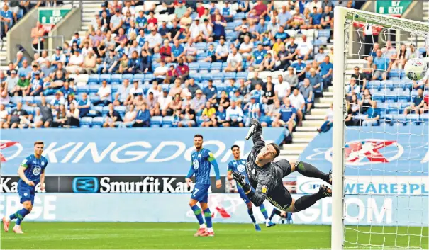  ??  ?? Crucial strike: Team-mates look on in admiration as Wigan’s Lee Evans (far left) curls a glorious shot past Cardiff goalkeeper Joe Day to put his team 3-2 up and on the way to three points at the DW Stadium