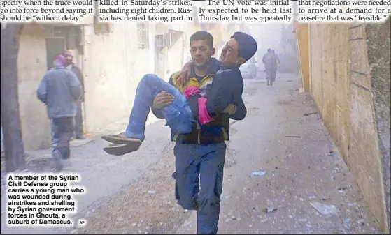  ?? AP ?? A member of the Syrian Civil Defense group carries a young man who was wounded during airstrikes and shelling by Syrian government forces in Ghouta, a suburb of Damascus.