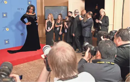  ?? DAN MACMEDAN/USA TODAY ?? Oprah Winfrey, hoisting her Cecil B. DeMille Award backstage Sunday night at the Golden Globes, brought the house down when she declared in her acceptance speech that “a new day is on the horizon” for women.