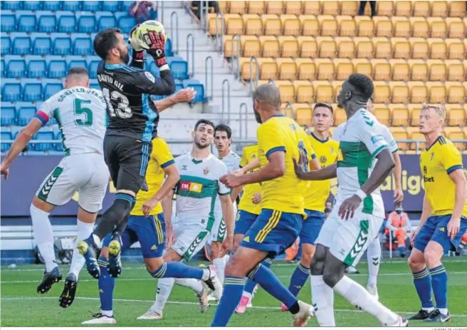  ?? LOURDES DE VICENTE ?? David Gil atrapa el balón entre un enjambre de jugadores del Cádiz y el Elche.