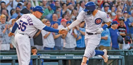 ?? MATT MARTON/AP ?? The Cubs’ Nick Castellano­s gets a hand from third-base coach Brian Butterfiel­d after his home run in the first inning Tuesday against the Giants.