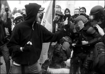  ?? JOHN MINCHILLO / ASSOCIATED PRESS ?? Supporters of then-President Donald Trump try to break through a police barrier Jan. 6 at the Capitol in Washington.