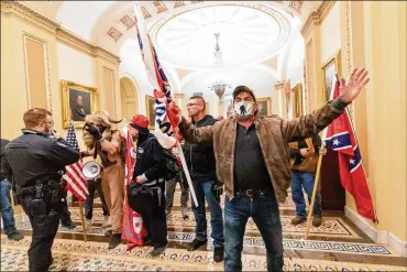  ?? MANUEL BALCE CENETA / AP ?? Protesters who broke into the U.S. Capitol are confronted by police near the Senate Chamber on Jan. 6 in Washington. Symbols of white supremacy and anti-government extremism were displayed by the mob.