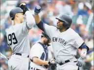  ?? Duane Burleson / Associated Press ?? The Yankees’ Edwin Encarnacio­n, right, celebrates his tworun home run against the Tigers with Aaron Judge (99) during the third inning in Game 1 in Detroit on Thursday.