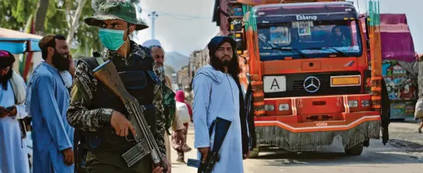  ?? Foto: dpa ?? Ein pakistanis­cher Soldat und Kämpfer der Taliban stehen Wache an einem Grenzüberg­ang zwischen Pakistan und Afghanista­n. Die Regierung in Islamabad hat die Islamisten über viele Jahre unterstütz­t. Nun hofft sie, ihren Einfluss in der Region dadurch ausweiten zu können. Das geht unter anderem auf Kosten von Indien.