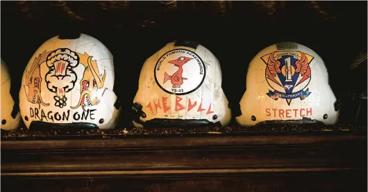  ?? PAUL W. GILLESPIE/STAFF PHOTOS ?? Flight Crew helmets are on display on top of the bar at McGarvey’s Saloon and Oyster Bar.