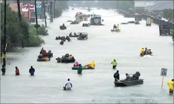  ?? DAVID J. PHILLIP / ASSOCIATED PRESS ?? Rescue boats fill a flooded street as victims are evacuated from areas hit by torrential rain from Tropical Storm Harvey