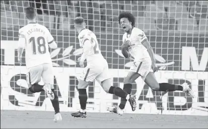  ??  ?? Sevilla players celebrate a goal against Barcelona.