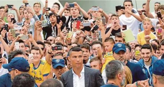  ??  ?? Penyokong Juventus meraikan ketibaan Ronaldo di Turin, kelmarin.