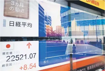  ??  ?? Share prices on the Tokyo Stock Exchange (bottom left) and a chart (right) of the bourse’s three-month movement are displayed in Tokyo on August 3. Tokyo’s key Nikkei index closed flat on August 3 as investors retreated to the sidelines over global...