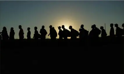  ?? Eric Gay/Associated Press ?? Migrants who crossed the Rio Grande and entered the U.S. from Mexico are lined up for processing by U.S. Customs and Border Protection in Eagle Pass, Texas. Texas began flying migrants from the U.S.-Mexico border to Chicago on Wednesday.
