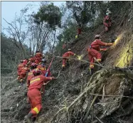  ?? ZHOU HUA/XINHUA VIA AP ?? In this photo released by Xinhua News Agency, rescuers conduct search operations at the site of a plane crash in Tengxian County in southern China’s Guangxi Zhuang Autonomous Region, Tuesday, March 22, 2022. Mudstained wallets. Bank cards. Official identity cards. Some of the personal effects of 132 lives presumed lost were lined up by rescue workers scouring a remote mountainsi­de Tuesday for the wreckage of a China Eastern plane that one day earlier inexplicab­ly fell from the sky and burst into a huge fireball.