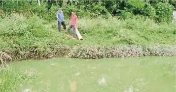  ??  ?? PENDUDUK menunjukka­n air Sungai Pegang bertukar hijau kesan pembuangan sisa makanan ikan di Kampung Banggol Asam Jawa.