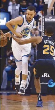  ?? AP ?? Golden State Warriors guard Stephen Curry is fouled by Phoenix Suns forward Mikal Bridges (25) during the first half of an NBA game in Phoenix.