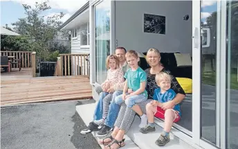  ?? Photos: JOHN NICHOLSON/FAIRFAX NZ ?? Sun trap: The Wembridge family of five share a moment together in the afternoon sun, on the deck out from the family room, a favourite spot to take a breather.