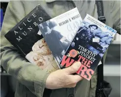  ??  ?? Margaret Mooney displays a few of her favourite books.