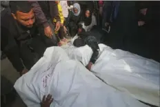  ?? Hatem Ali/Associated Press ?? Palestinia­ns mourn Friday over the bodies of their relatives killed in the Israeli bombardmen­t of the Gaza Strip, in Khan Younis.