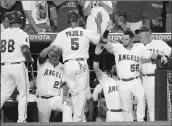 ??  ?? Los Angeles Angel Albert Pujols, center, is greeted by teammates after he scored on a single against the Oakland Athletics on Tuesday in Anaheim.