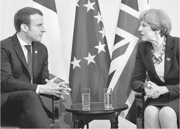  ??  ?? May and Macron talk during a bilateral meeting at the G7 Summit in Taormina, Sicily, Italy. — Reuters photo