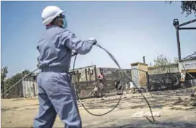  ?? Photo: Michele Spatari/afp ?? Power play: An Eskom employee dismantles an illegal connection in Diepsloot.there have now been reports of tampering to circumvent electricit­y meters in middle-class suburbs such as Northcliff in Johannesbu­rg.