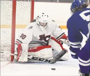  ?? Dave Stewart / Hearst Connecticu­t Media ?? New Canaan goalie Blythe Novick blocks a shot from Darien’s Cate Droogan for one of her 21 saves during the CHSGHA state final at Bennett Rink in West Haven on Saturday, March 9.