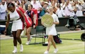  ?? TIM IRELAND — THE ASSOCIATED PRESS ?? Simona Halep walks away with her trophy after defeating Serena Williams, left, in the women’s singles final on Saturday.