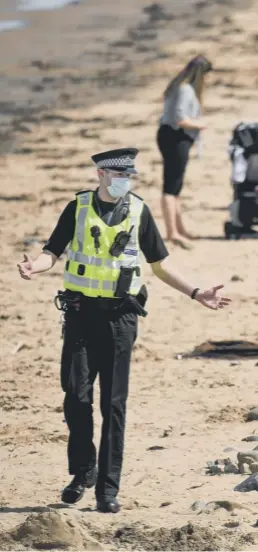  ??  ?? 0 A policeman patrolling Portobello Beach talks to one of the many