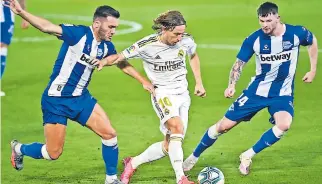  ??  ?? CONDUCCIÓN. Luka Modric se sacude el marcaje de Lucas Pérez y Oliver Burke.