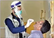  ?? PTI ?? A health worker takes a nasal swab sample of a person during doorto-door testing and screening facility for the new Coronaviru­s, in Islamabad, Pakistan, Monday