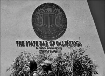  ?? AP Photo/Ashley Landis ?? People walk past the entrance of The State Bar of California office on Thursday, April in Los Angeles.