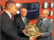  ?? PAUL POST -- PPOST@DIGITALFIR­STMEDIA.COM ?? GlobalFoun­dries Chief Executive Officer Tom Caulfield, right, presents a commemorat­ive computer chip wafer to Mubadala Investment Company Chief Executive Officer Kaldoon Khalifa Al Mubarak, left, as U.S. Rep. Paul Tonko, D-Amsterdam, looks on.