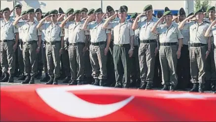  ?? KENAN GURBUZ / REUTERS ?? Policías turcos saludan el féretro de un oficial caído durante el golpe