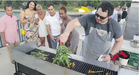  ?? NICK BRANCACCIO ?? Dinner on a Pier guests from left, Wes Yik, Maaya Kaul, Radha Patel, Adam El-Dika and Istar Dahir watch chef Chris Chittle on the barbecue during the WindsorEat­s event at Ambassador Park.