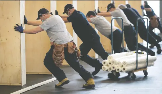  ?? PIERRE OBENDRAUF ?? Workers install dormitorie­s at the Stade de soccer de Montréal on Thursday in preparatio­n for 150 Covid-19-positive homeless people to self-isolate and quarantine.