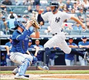  ?? The Associated Press ?? New York Yankees' Giancarlo Stanton, right, evades the tag by Toronto Blue Jays catcher Reese McGuire Sunday in NewYork.The Jays won 3-2.