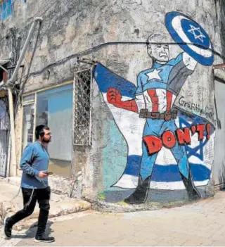  ?? ?? Grafiti en un edificio de Tel Aviv, en el que Biden está caricaturi­zado como el Capitán América // REUTERS