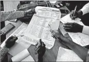  ?? JEROME DELAY/AP ?? Officials tally presidenti­al ballots Friday in Kinshasa, Congo, where the first results are expected Sunday.