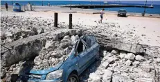  ??  ?? Ein Auto ist auf der Insel Kos in Strandnähe unter Trümmern begraben.