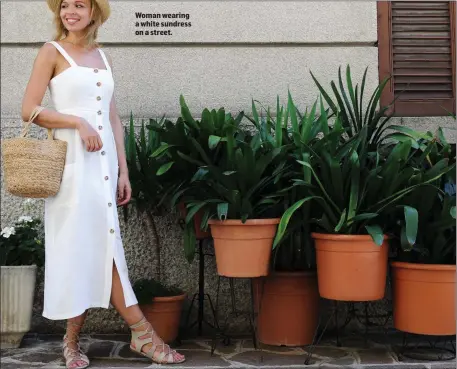  ??  ?? Woman wearing a white sundress on a street.