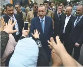  ??  ?? Le président turc Recep Tayyip Erdogan (C) quittant le bureau de vote après avoir glissé son bulletin dans l’urne, hier, à Istanbul