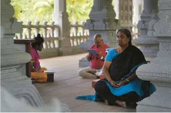  ?? JESSIE WARDARSKI/AP ?? Devajyothi Kondapi, of Portland, Ore., meditates as her husband practices a chant in the Iraivan Temple.