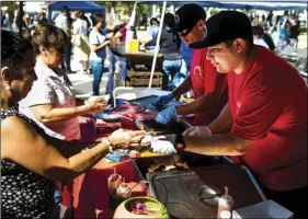  ??  ?? Andres Soto (right) of the Zawameros booth serves a customer some ribs during the Brawley Elks Lodge’s second annual Oktoberfes­t Rib Cook-Off held Saturday afternoon on South Plaza Street in Brawley. PHOTO VINCENT OSUNA