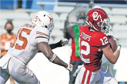  ??  ?? Oklahoma's Drake Stoops (12) runs to the end zone past Texas' Chris Brown (15) in the fourth overtime of the Sooners' 53-45 win Oct. 10 at the Cotton Bowl in Dallas. [BRYAN TERRY/ THE OKLAHOMAN]