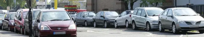  ??  ?? Car park dormitory: Some of the vehicles used by the group, who are accused of pestering shoppers for work as they arrive at nearby stores including Halfords and Asda