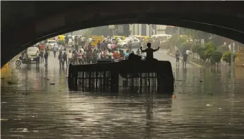  ?? — PRITAM BANDYOPADH­YAY ?? A DTC bus stands stranded after waterloggi­ng due to heavy rains at Minto Bridge in Connaught Place on Monday.