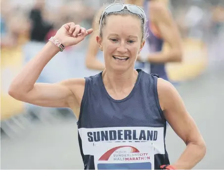  ??  ?? Sunderland Stroller Alyson Dixon celebrates being the first female to cross the line in the Sunderland Half Marathon last month.