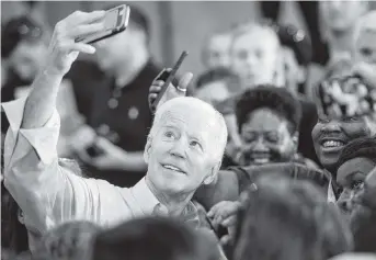  ?? SEAN RAYFORD Getty Images ?? As a candidate, Joe Biden takes photos with people in the crowd at a campaign event in Columbia, South Carolina.