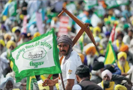  ?? ADNAN ABIDI / REUTERS ?? A farmer holds a mock plow as he attends a protest in New Delhi on Thursday to press for better crop prices promised to them in 2021.