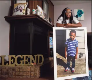  ?? Charlie Riedel / Associated Press ?? Charron Powell stands with a photo of her son, LeGend Talieferro, at her home in Raytown, Mo., on Oct. 3. LeGend was 4 years old when he was fatally shot June 29, 2020, as he was sleeping in an apartment while staying with his father.